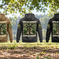 Five separate Arborist Once and Always Vintage Hoodie back views in Military Green, Kaki, Dark Gray, Black and Dark Blue beneath living tree canopy, with coiled climbing rope and a sheathed pruning saw resting nearby.