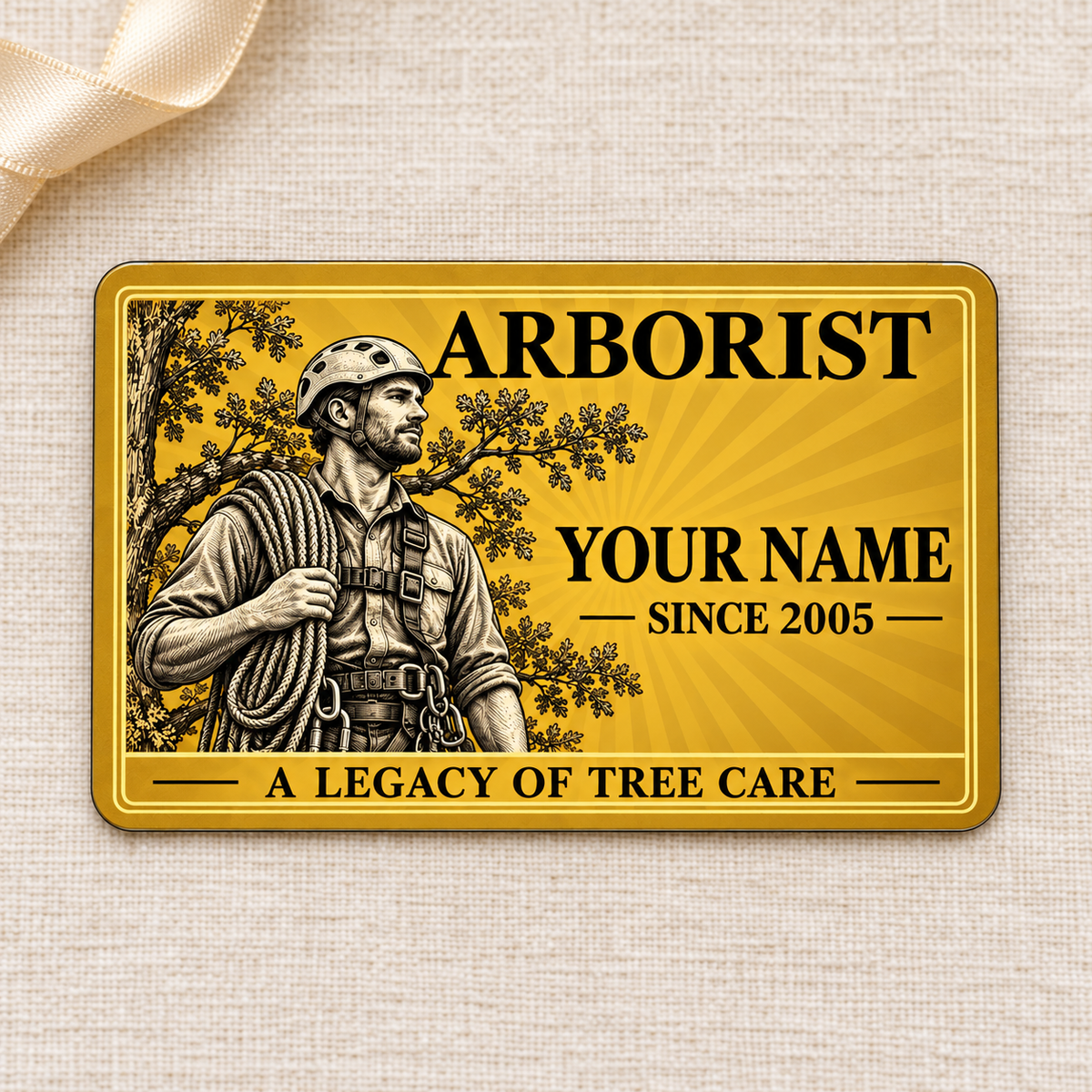 Arborist Golden Milestone aluminum wallet card, front view on cream linen.