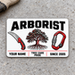 Front of the Arborist Minimal Tool Grid aluminum wallet card on light concrete.