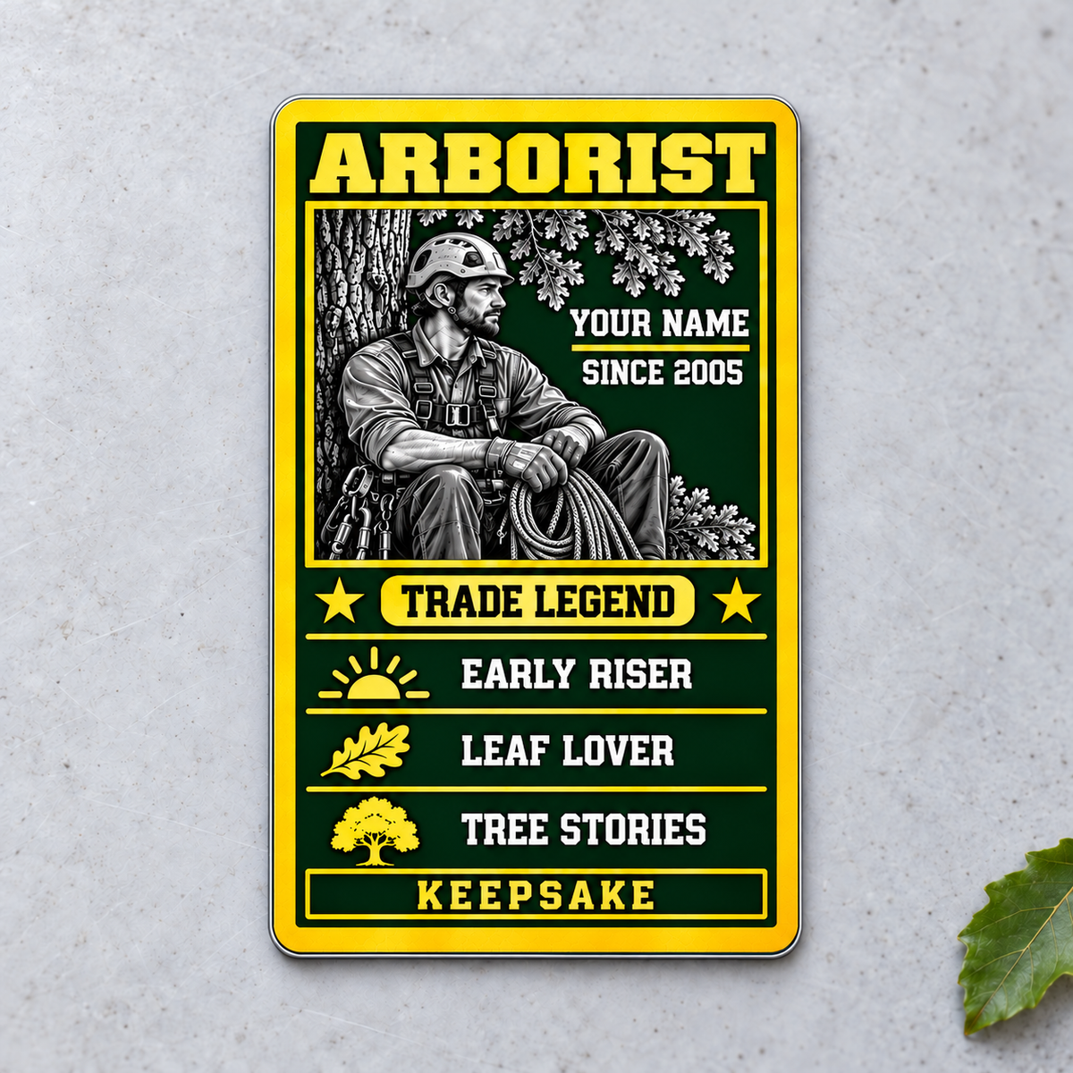 Arborist Trade Legend aluminum wallet card, portrait front view on pale concrete.