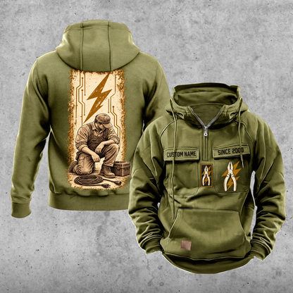 Electrician Workday Portrait Vintage Hoodie in Military Green, front and back views with sample text CUSTOM NAME and SINCE 2000, pliers and lightning-bolt chest emblems, and a kneeling electrician beside a closed tool case and disconnected cable in a tall circuit panel.