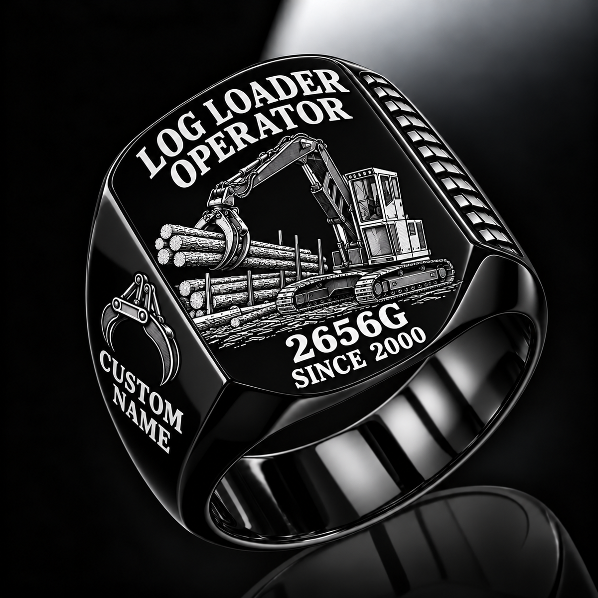 John Deere 2656G Log Loader Operator Ring in Black finish, flat engraving showing plain two-jaw log grapple on a loading boom, CUSTOM NAME and SINCE 2000.