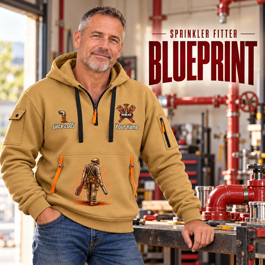 Sprinkler Fitter Blueprint Quarter-Zip Hoodie in Khaki, worn by an adult male model, preserving the current niche artwork, sample name and year, and hooded quarter-zip garment details.