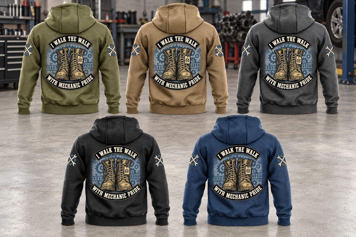 Five complete back views of Mechanic Walk the Walk Badge Vintage Hoodie in Military Green, Kaki, Dark Gray, Black and Dark Blue, arranged in a quiet vehicle workshop with arched I WALK THE WALK and WITH MECHANIC PRIDE boots artwork.