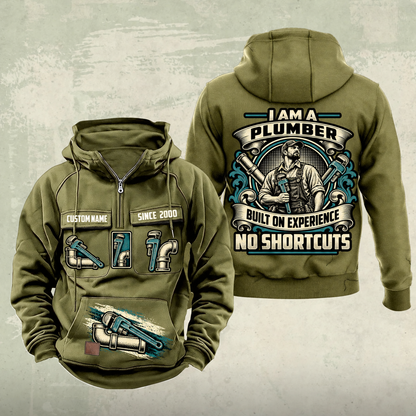 Plumber Heritage Crest Vintage Hoodie in Military Green, front and back views with cream and muted teal plumbing artwork and sample chest text CUSTOM NAME and SINCE 2000.