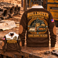 Brown Bulldozer Operator Hands Behind the Blade Sports Sweatshirt, front and back views with tracked-bulldozer print, cream yoke and collar, and brown elbow details on a workshop bench.