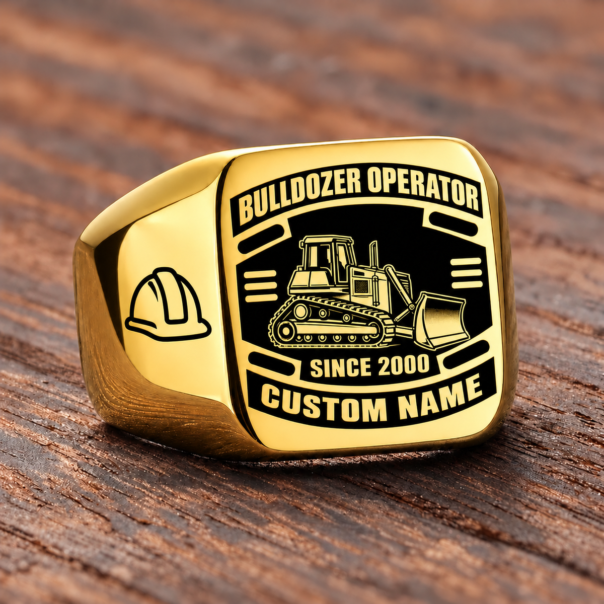 Gold Bulldozer Operator Black Face Badge ring with a tracked bulldozer and front pushing blade on the black face, a hard-hat shoulder motif, and sample CUSTOM NAME and SINCE 2000 engraving.