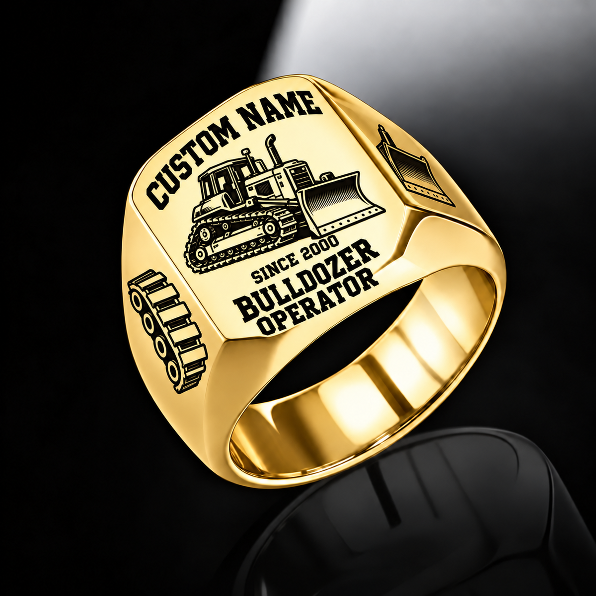 Gold Bulldozer Operator Bold Lettering signet ring with a tracked bulldozer and pushing blade, track-link and blade shoulder motifs, a plain inner band, and sample CUSTOM NAME and SINCE 2000 engraving.
