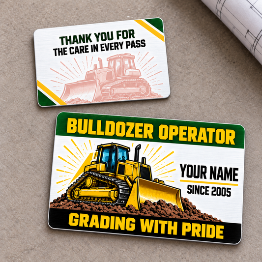 Front and reverse of the Bulldozer Operator Green Band aluminum wallet card on a neutral tabletop, with yellow tracked bulldozer artwork, green header, black Grading with Pride footer and a pale matching thank-you reverse.