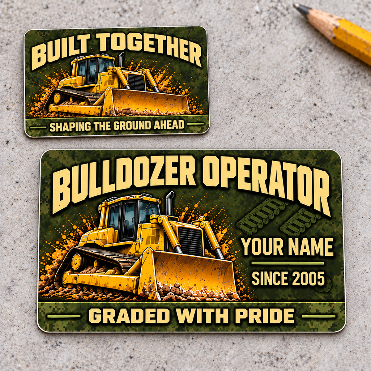 Front and reverse of the Bulldozer Operator Rugged Field aluminum wallet card, offset on pale concrete, with olive pixel camouflage, tan lettering and a yellow tracked bulldozer with front blade.