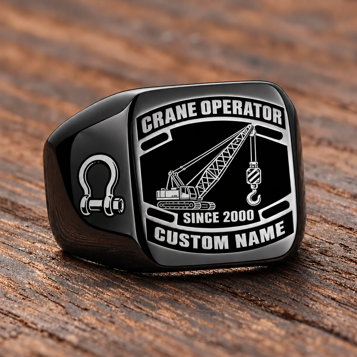 Black-finish Crane Operator Black Face Badge ring with lattice crane, suspended hoist hook, shoulder shackle and illustrated CUSTOM NAME and SINCE 2000 text