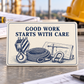 Reverse of the Crane Operator Built by Skill aluminum wallet card, with Good Work Starts with Care in indigo above a printed crane hook block, coiled wire rope, shackle and lift-plan illustration on ivory.