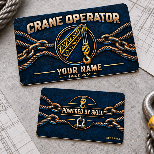 Front and reverse views of one Crane Operator Craft Camo aluminum wallet card on a gray planning workbench, with navy textured camo, copper-toned crane boom, hoist and hook artwork, printed steel rigging ropes and connected links with cyan highlights, illustrative YOUR NAME text, and a Powered by Skill reverse with hook and shackle.