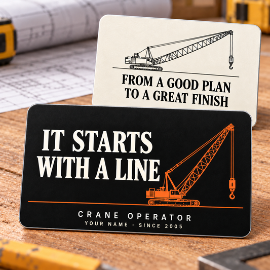 Crane Operator First Lift printed aluminum wallet card shown with a black front reading It Starts with a Line and an ivory reverse reading From a Good Plan to a Great Finish, with matching crane illustrations on a planning tabletop.