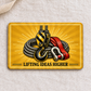 Reverse of the Crane Operator Golden Milestone aluminum wallet card on cream linen, with a hoist hook, coiled steel wire rope, red sling, shackle, and LIFTING IDEAS HIGHER message.