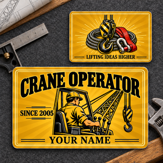 Front and reverse views of one Crane Operator Golden Milestone aluminum wallet card on a crane planning workbench, with golden sunburst artwork and illustrative SINCE 2005 and YOUR NAME text.