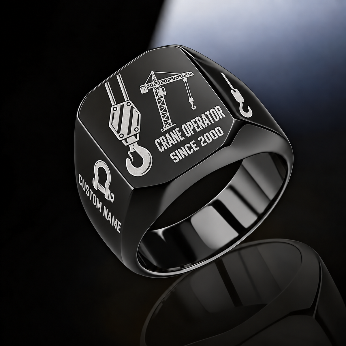 Black-finish Crane Operator Split Emblem signet ring with split-face hoist hook and tower crane, plus bow-shackle and hook shoulder motifs and illustrated CUSTOM NAME and SINCE 2000 text