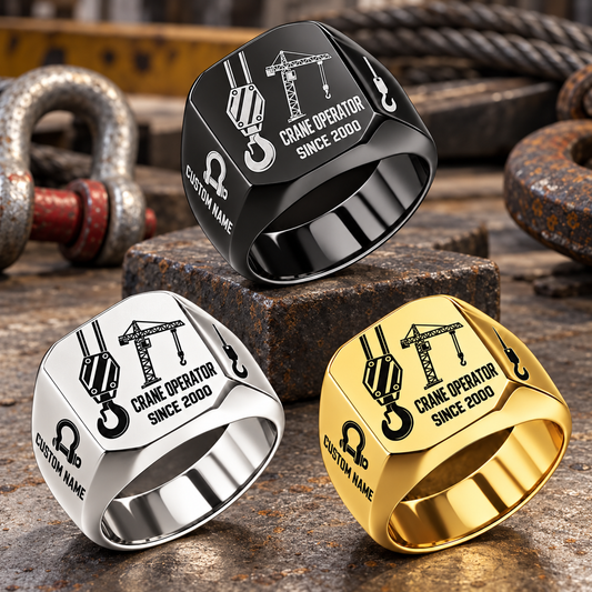 Crane Operator Split Emblem signet rings in a Black-led triangular arrangement, with Silver and Gold finishes on a staged crane-rigging workbench