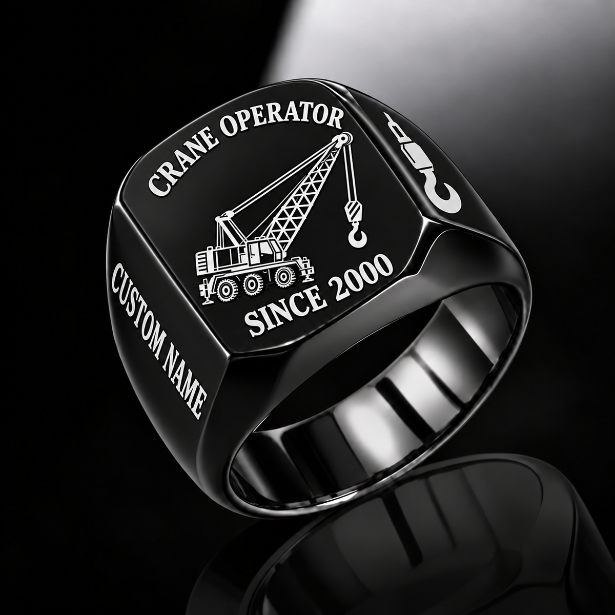 Black-finish Crane Operator Trade Emblem signet ring with lattice-boom crane, suspended hoist, shoulder hook and illustrated CUSTOM NAME and SINCE 2000 text