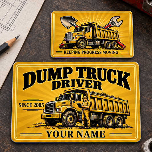 Front and reverse of the Dump Truck Driver Golden Milestone aluminum wallet card, with gold sunburst artwork, dump trucks and sample name and year text on a dispatch-planning workbench.