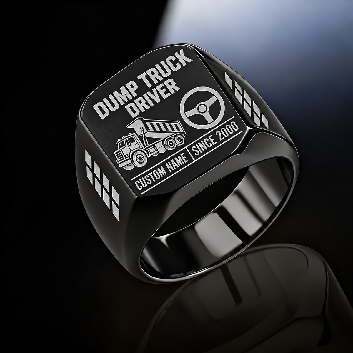 Black-finish Dump Truck Driver Twin Icons signet ring with raised-bed dump truck and steering wheel icons, tire-tread shoulders, and illustrated CUSTOM NAME and SINCE 2000 text