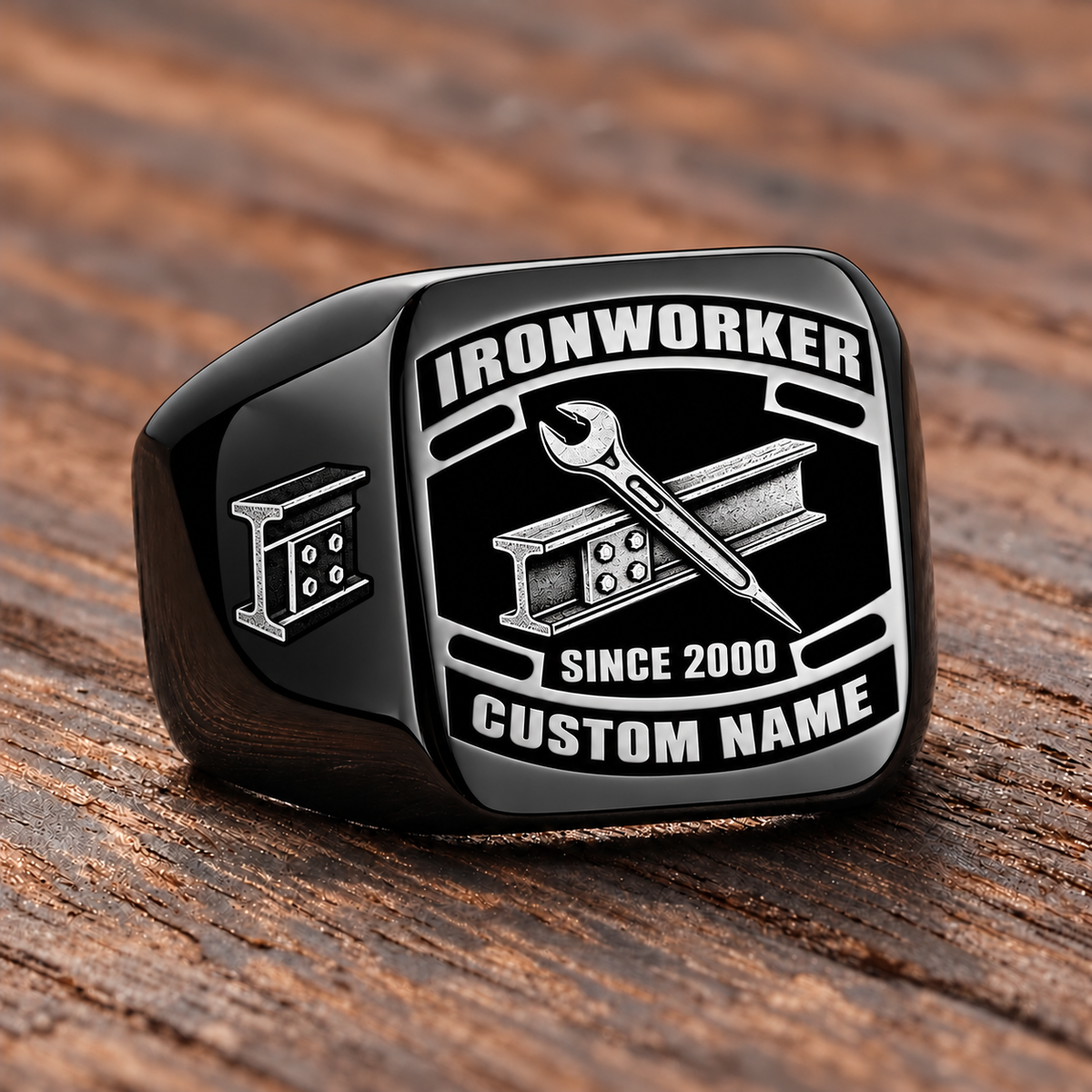 Black-finish Ironworker Black Face Badge ring with bolted structural I-beam and pointed spud wrench artwork, shoulder bolted I-beam emblem and illustrated CUSTOM NAME and SINCE 2000 text