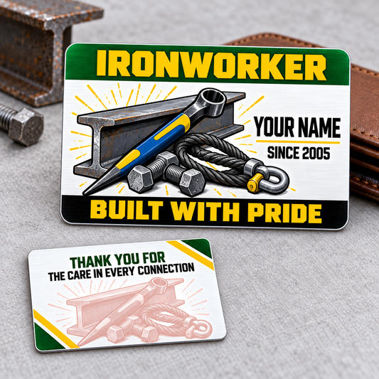Front and reverse of an Ironworker Green Band aluminum wallet card, with yellow lettering, green and black bands, blue-and-yellow spud wrench, I-beam and rigging artwork on gray cloth beside a brown wallet.