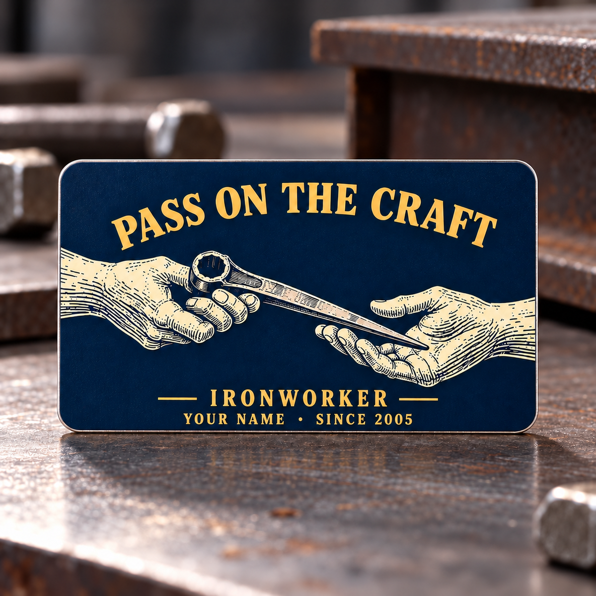 Ironworker Pass on the Craft aluminum wallet card front in midnight blue, with cream engraved-style hands passing a tapered spud wrench and gold lettering.