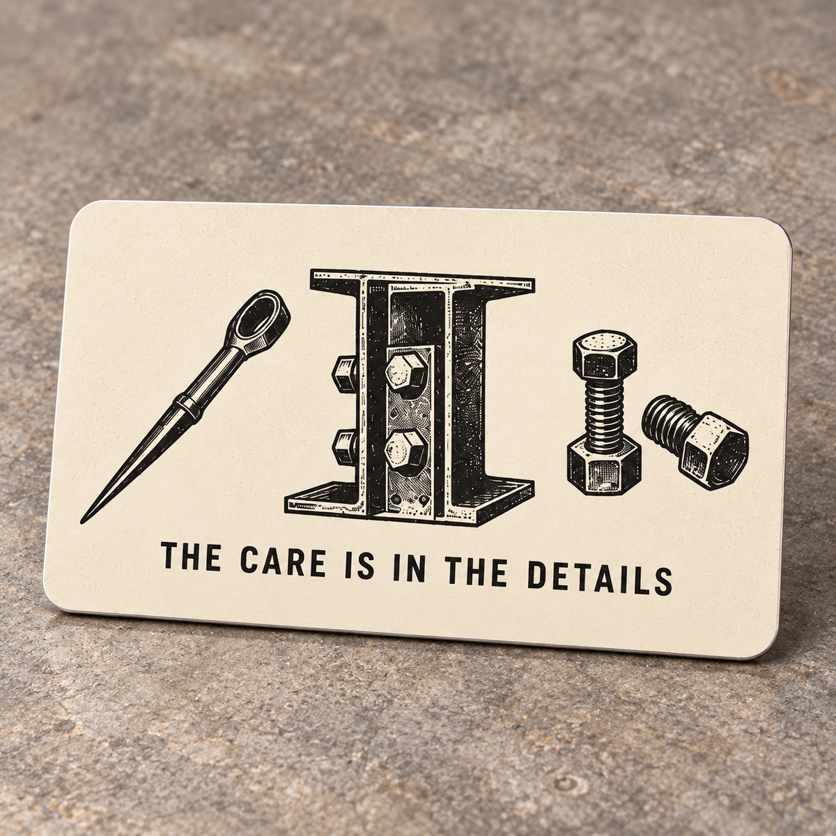 Cream reverse of the Ironworker aluminum wallet card with black spud-wrench, bolted I-beam and hex-bolt illustrations above The Care Is in the Details.