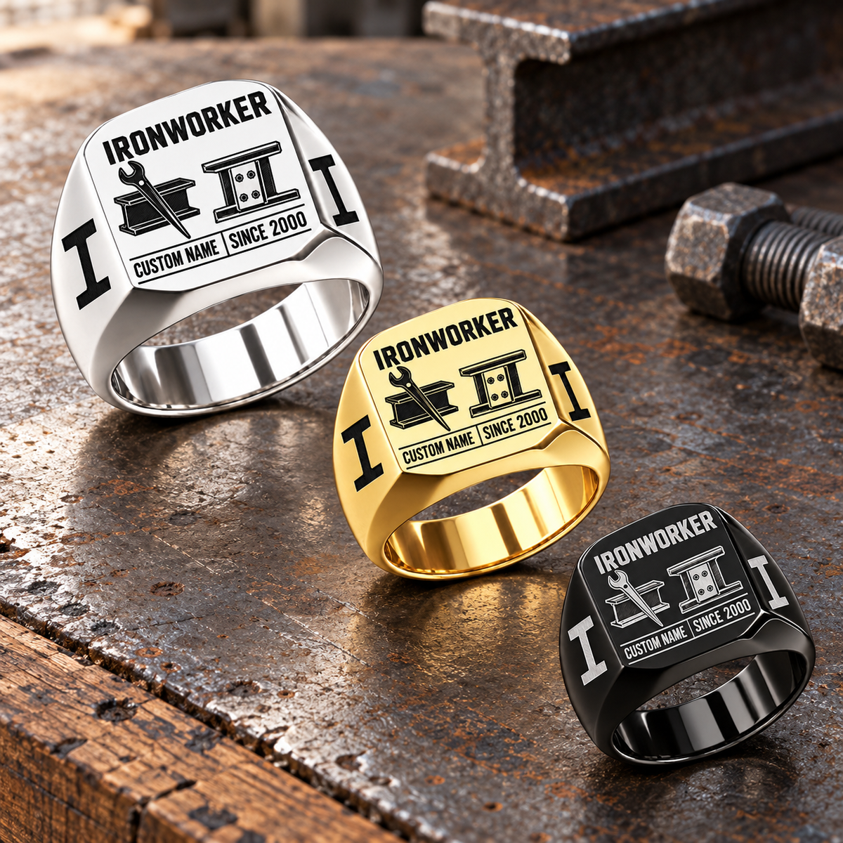 Ironworker Twin Icons signet rings in a Silver-led descending diagonal with Gold and Black on a stationary structural steel tabletop