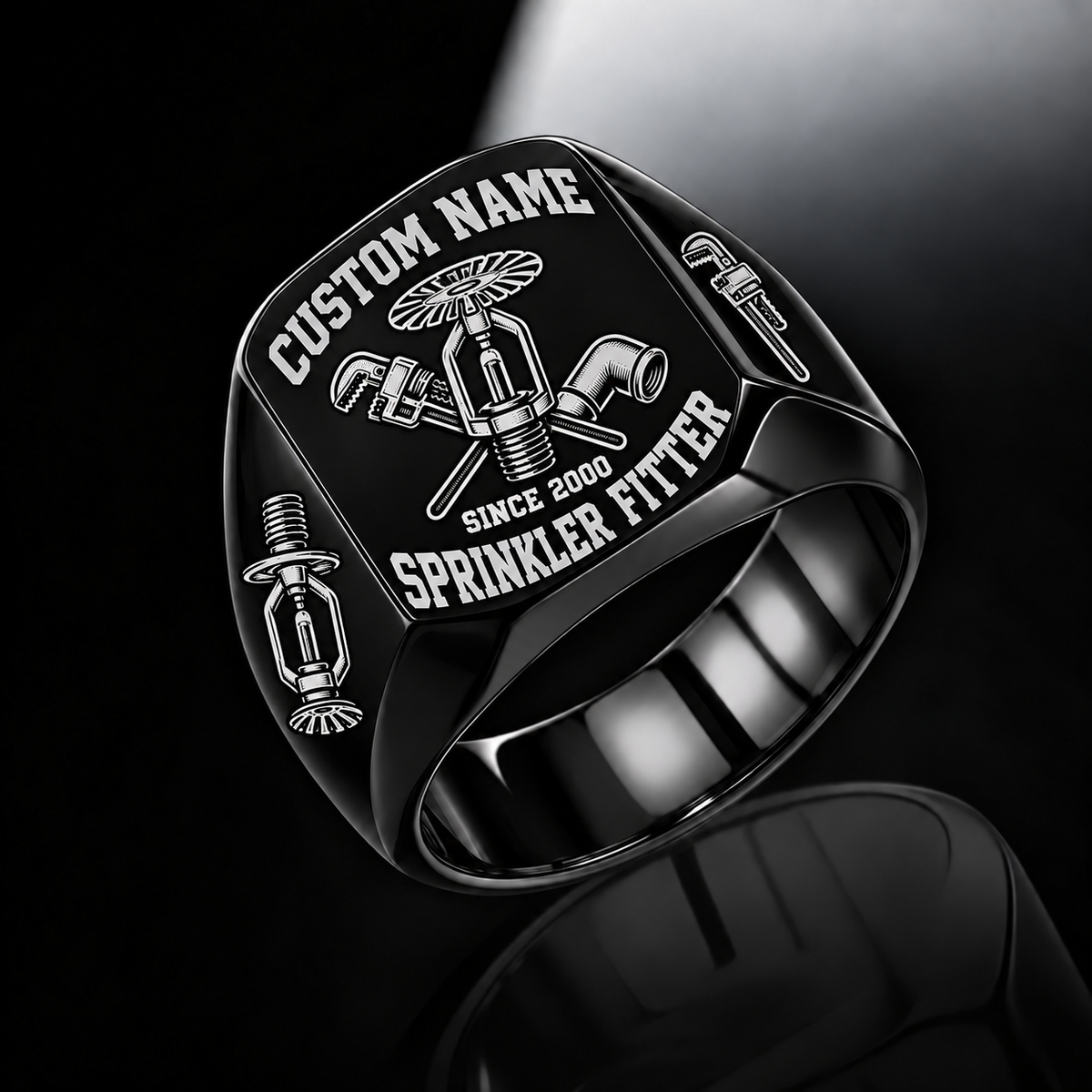 Black-finish Sprinkler Fitter Bold Lettering signet ring with fire-sprinkler, pipe-wrench and pipe-elbow engraving, and illustrated CUSTOM NAME and SINCE 2000 text