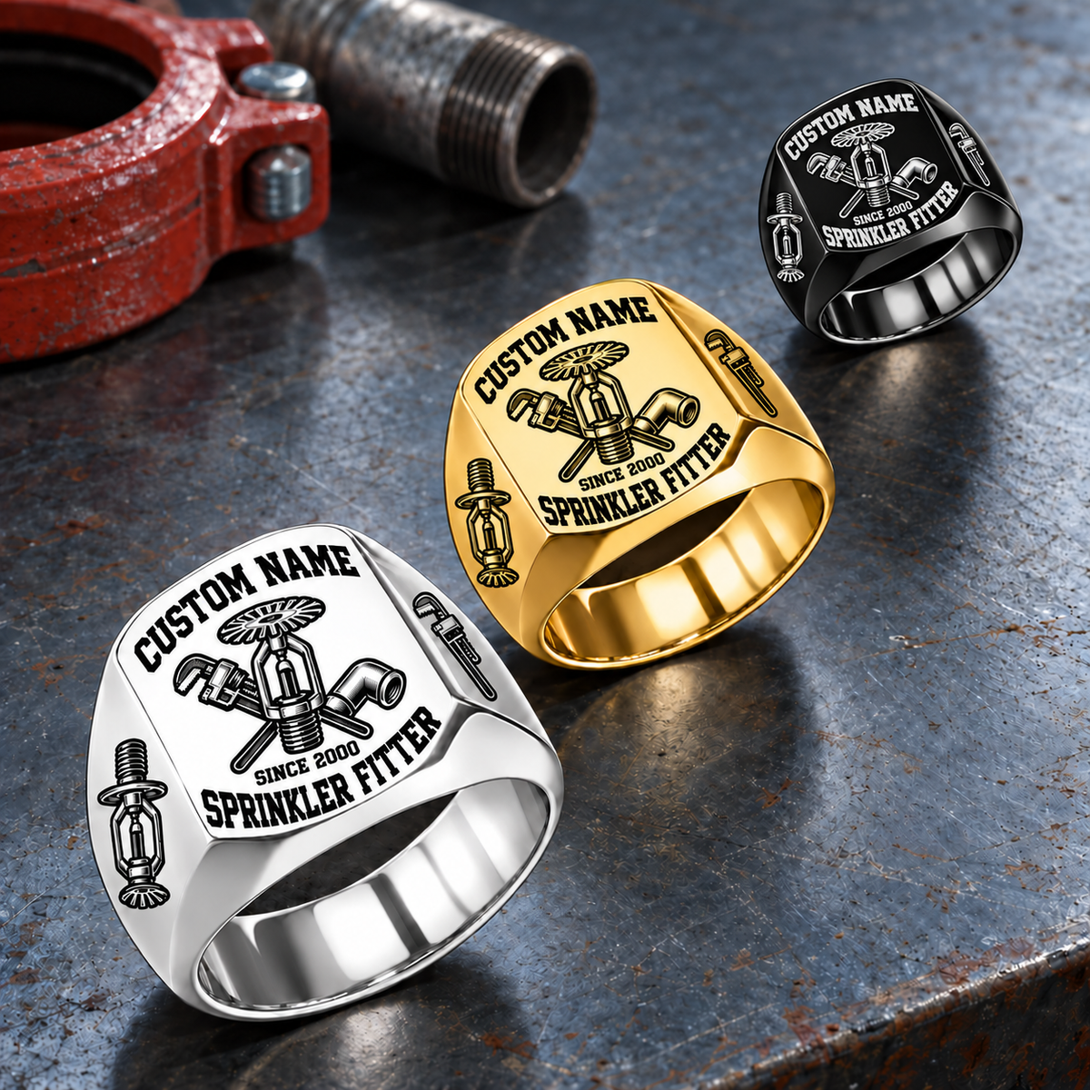 Sprinkler Fitter Bold Lettering rings: dominant Silver ring at lower left, Gold in the middle and Black at upper right on a stationary sprinkler-fitting workbench