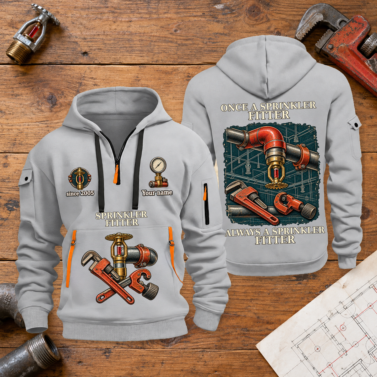 Sprinkler Fitter Proud of the Trade Quarter-Zip Hoodie in Light Grey, full authentic front and back views with matching sprinkler fitter tools and equipment artwork, original sample name/year and once-and-always trade motto. On a sprinkler fitter workbench.