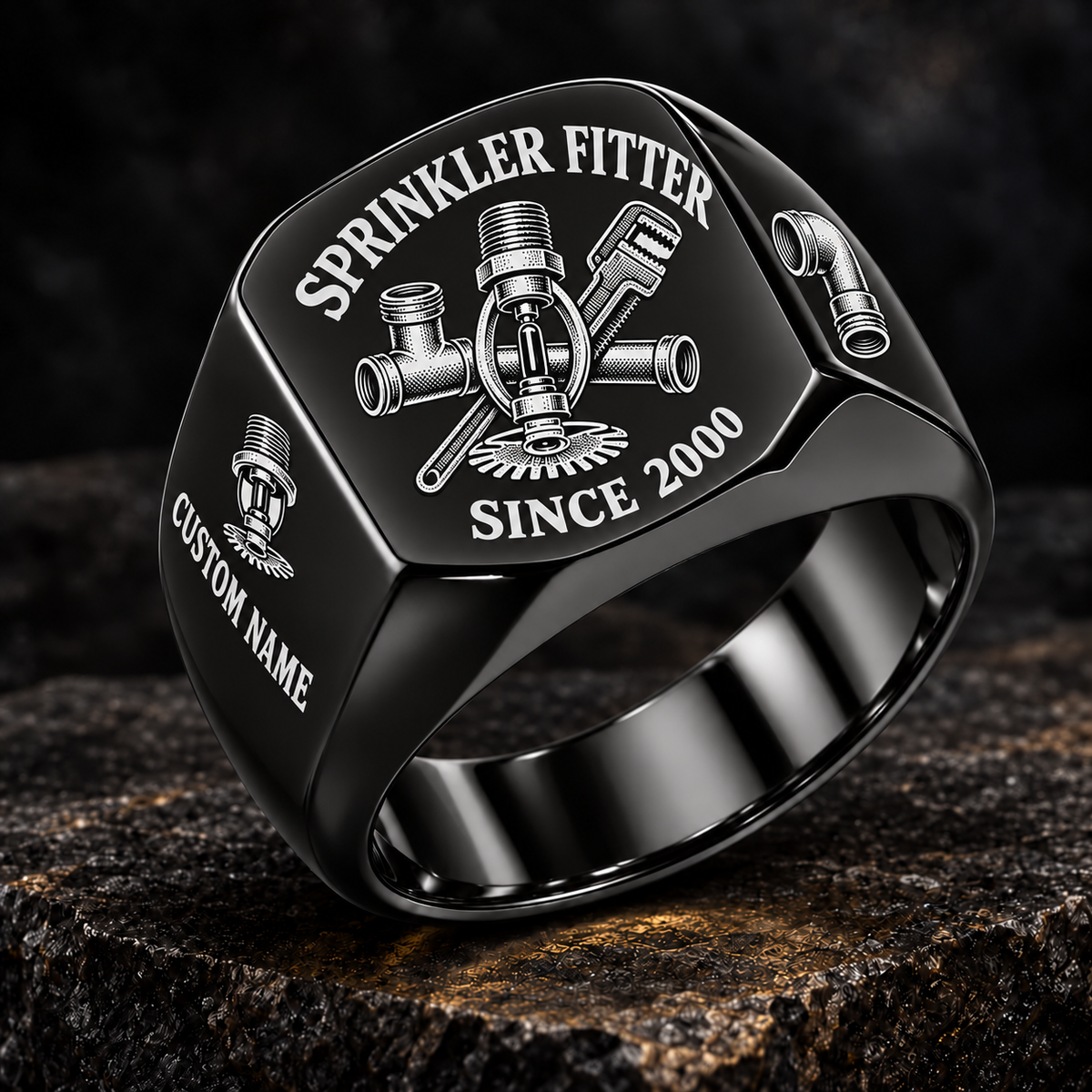 Black-finish Sprinkler Fitter Heritage Emblem signet ring with pendent fire-sprinkler head, connected tee fitting and pipe wrench engraving, illustrated CUSTOM NAME and SINCE 2000 text