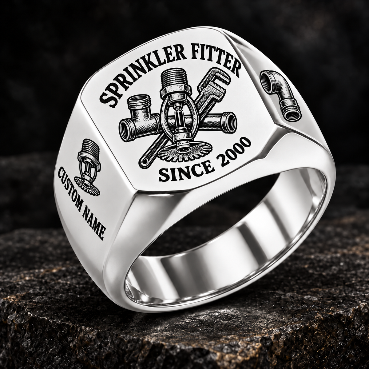 Silver-finish Sprinkler Fitter Heritage Emblem signet ring with pendent fire-sprinkler head, connected tee fitting and pipe wrench engraving, illustrated CUSTOM NAME and SINCE 2000 text