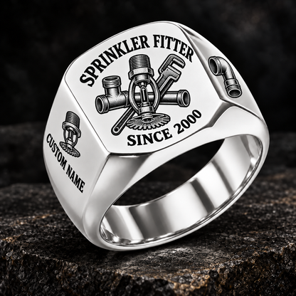 Silver-finish Sprinkler Fitter Heritage Emblem signet ring with pendent fire-sprinkler head, connected tee fitting and pipe wrench engraving, illustrated CUSTOM NAME and SINCE 2000 text