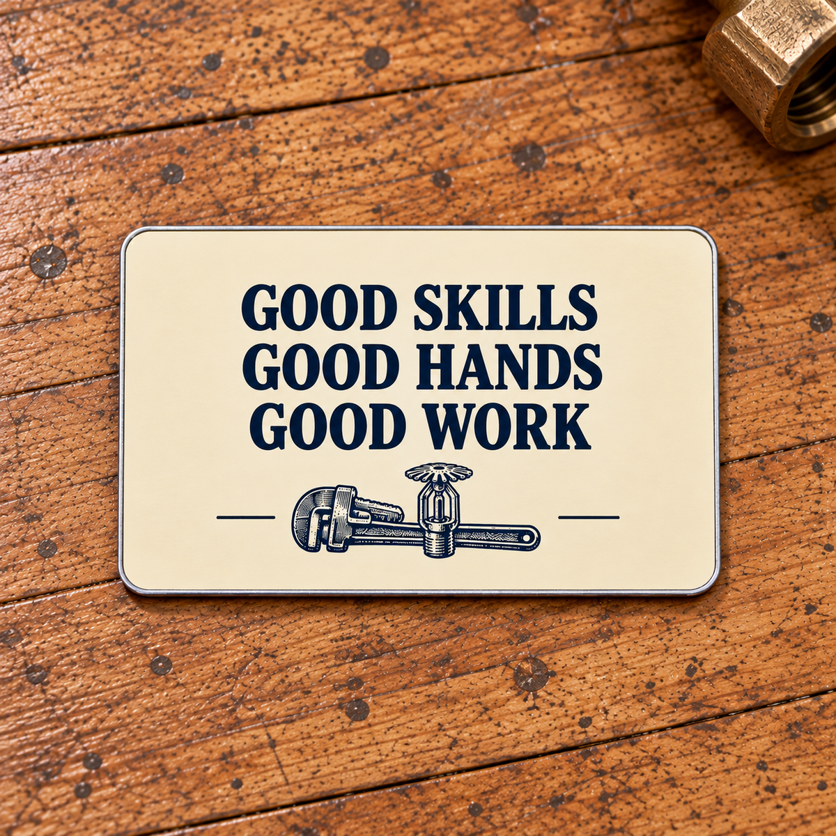 Ivory reverse of the Sprinkler Fitter Pass on the Craft aluminum wallet card, with navy Good Skills, Good Hands, Good Work lettering and a small pipe-wrench and fire-sprinkler motif.