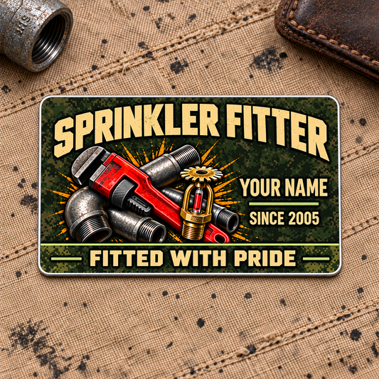 Sprinkler Fitter Rugged Field Aluminum Wallet Card, complete front with olive camouflage and tan printed artwork, pipe-wrench, steel pipework and fire-sprinkler motifs. Fixed illustrative artwork as shown.