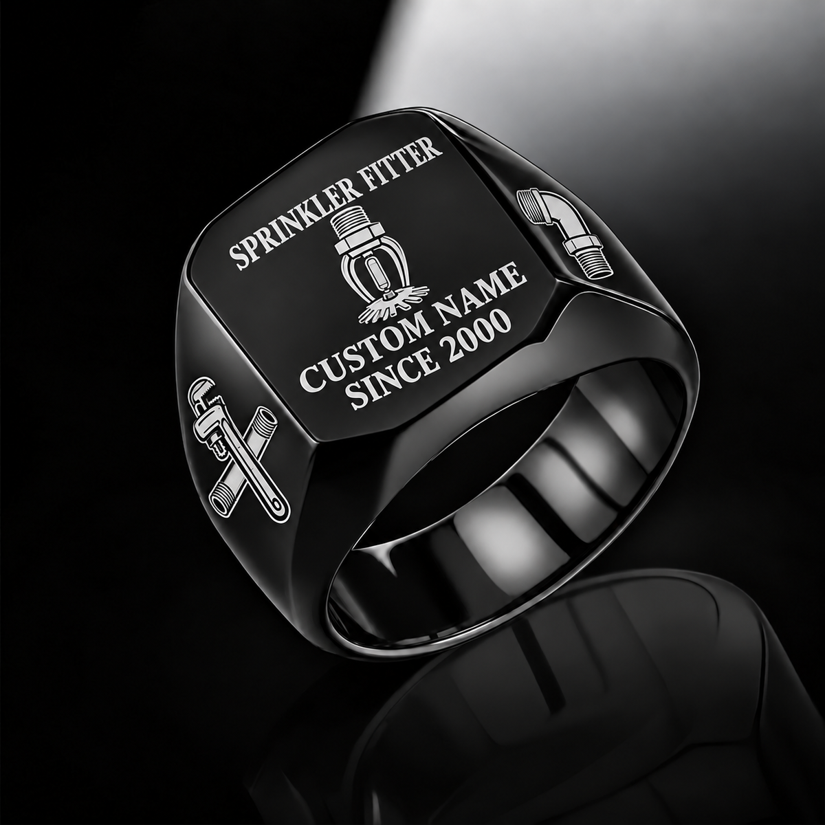Black-finish Sprinkler Fitter Signature Crest signet ring with pendent fire-sprinkler head, pipe wrench and threaded-pipe shoulder engraving, and illustrated CUSTOM NAME and SINCE 2000 text
