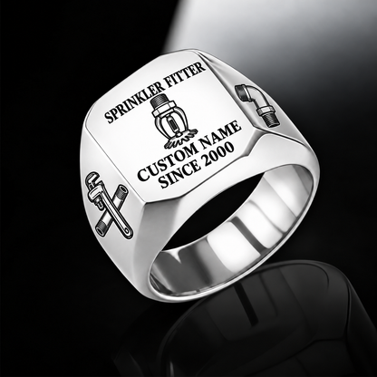 Silver-finish Sprinkler Fitter Signature Crest signet ring with pendent fire-sprinkler head, pipe wrench and threaded-pipe shoulder engraving, and illustrated CUSTOM NAME and SINCE 2000 text