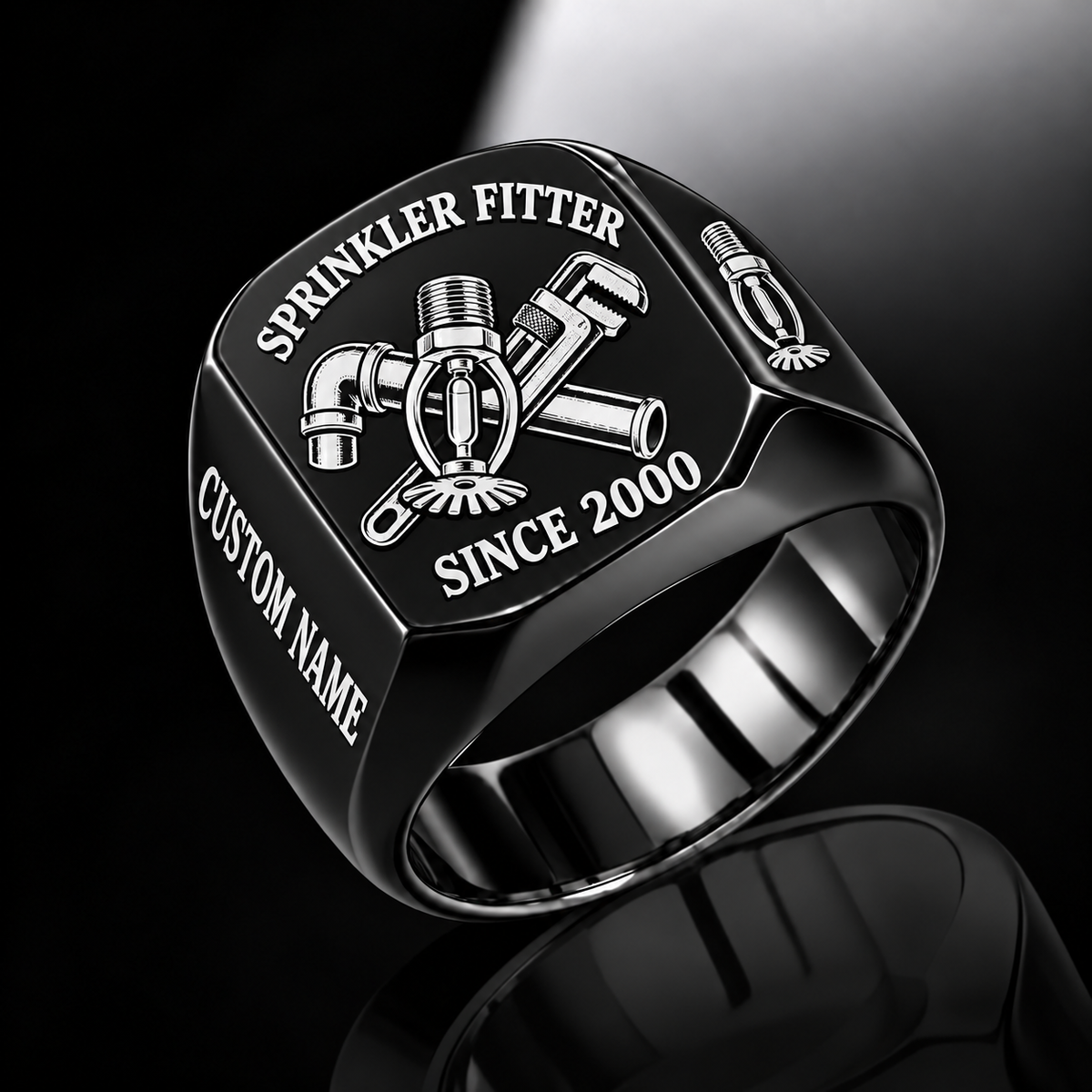 Black-finish Sprinkler Fitter Trade Emblem signet ring with pendent fire sprinkler, connected pipe fitting, pipe wrench and illustrated CUSTOM NAME and SINCE 2000 text