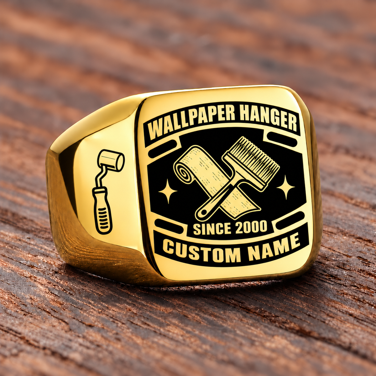 Gold-finish Wallpaper Hanger Black Face Badge signet ring with crossed wallpaper roll and pasting brush, smooth seam-roller shoulder icon, and illustrated CUSTOM NAME and SINCE 2000 text