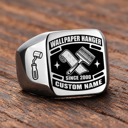 Silver-finish Wallpaper Hanger Black Face Badge signet ring with crossed wallpaper roll and pasting brush, smooth seam-roller shoulder icon, and illustrated CUSTOM NAME and SINCE 2000 text