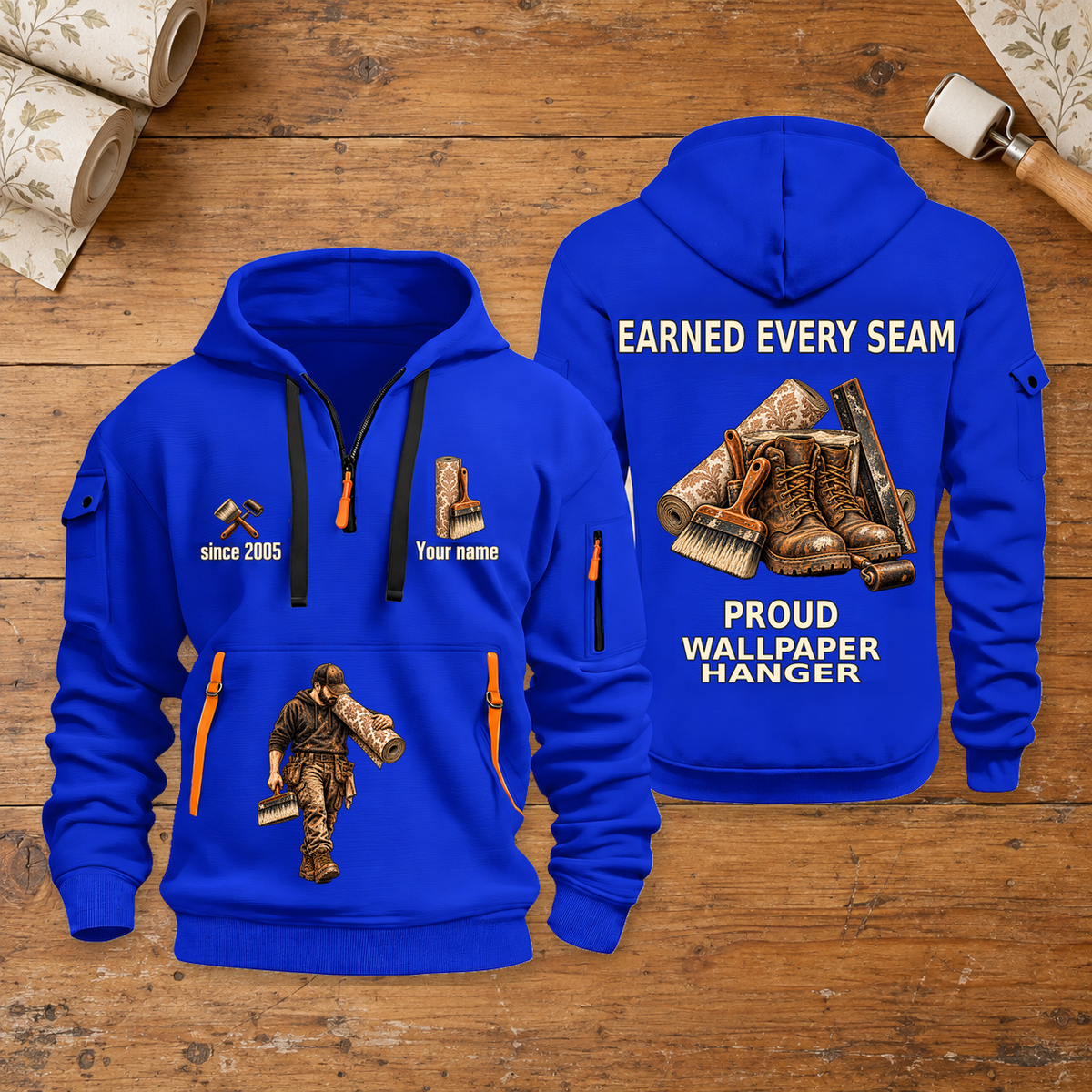 Wallpaper Hanger Earned Every Seam Quarter-Zip Hoodie in Blue, full authentic front and back views with matching wallpaper hanger tools and equipment artwork, original sample name/year and Earned Every slogan. On a wallpaper hanger workbench.