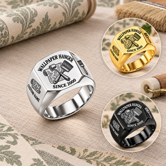 Wallpaper Hanger Heritage Emblem rings: dominant Silver ring with smaller Gold and Black finish insets on a stationary wallpaper worktable