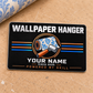 Overhead front view of the Wallpaper Hanger Midnight Pride aluminum wallet card, with black face, silver Wallpaper Hanger and illustrative YOUR NAME text, wallpaper roll and seam roller motif, copper circular frame, straight blue and copper stripes, and Powered by Skill.