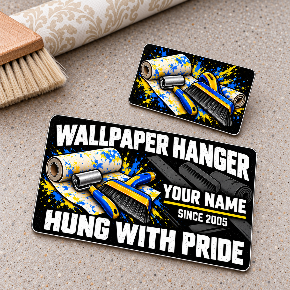 Wallpaper Hanger Midnight Splatter aluminum wallet card, showing its lettered front and graphic-only reverse on a wallpaper workbench