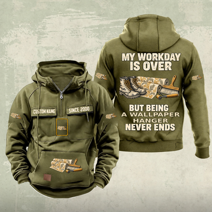 Wallpaper Hanger Never Ends Vintage Hoodie in Military Green, front and back, with work boots and wallpaper rolls, a smoothing brush and seam roller, matching sleeve, chest and pocket motifs, and illustrative CUSTOM NAME and SINCE 2000 text.