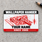 Front of the Wallpaper Hanger Red Monochrome aluminum wallet card on light-gray concrete, with illustrative YOUR NAME and SINCE 2005 text.