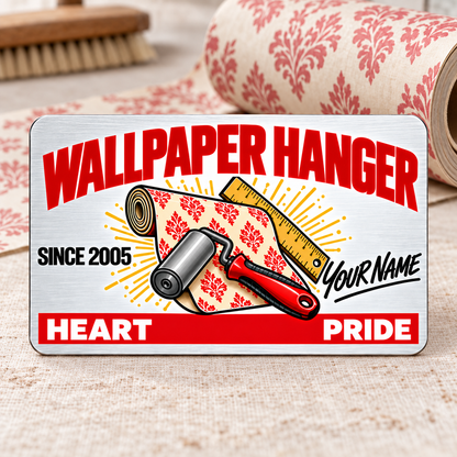 Upright front of a white brushed-aluminum Wallpaper Hanger Signature Classic wallet card with red heading, wallpaper roll, seam roller, ruler, illustrative SINCE 2005 and Your Name text, and HEART and PRIDE footer.